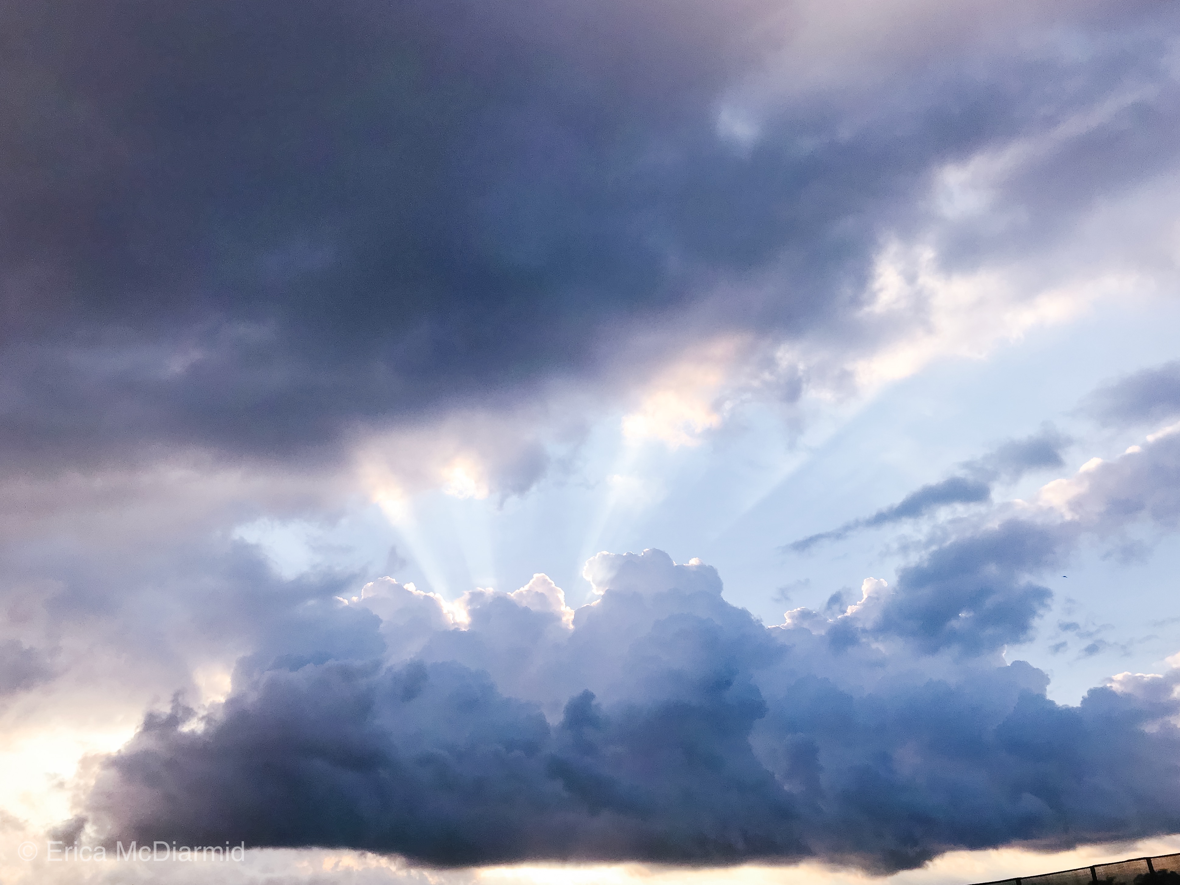 sunbeams coming out of a cloud at sunset